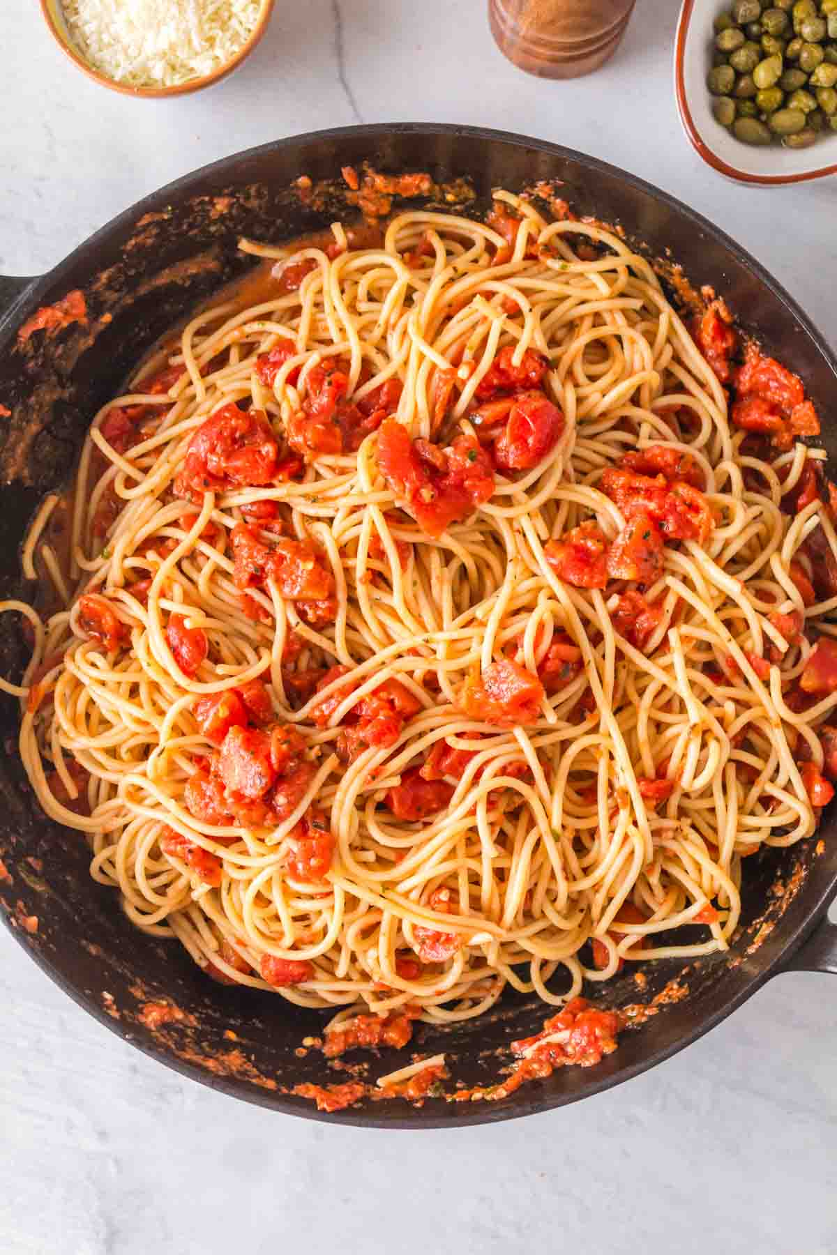 pasta puttanesca with red sauce and in a pan
