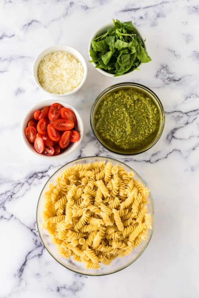 portion bowls of ingredients for pesto pasta salad