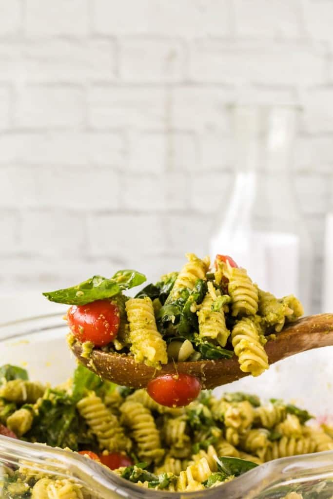 a spoonful of pesto pasta salad with shredded parmesan cheese