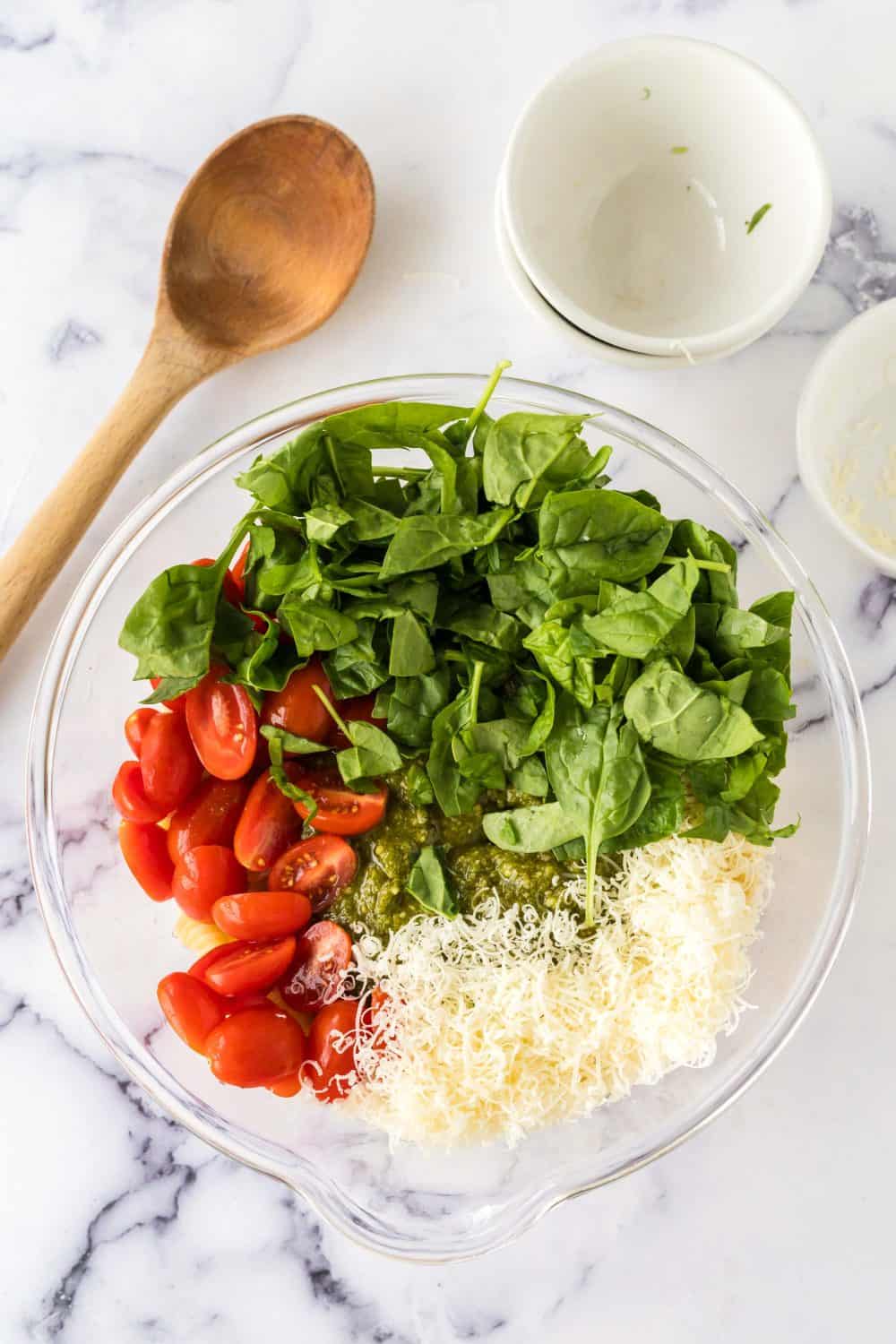 pesto pasta salad ingredients in a bowl