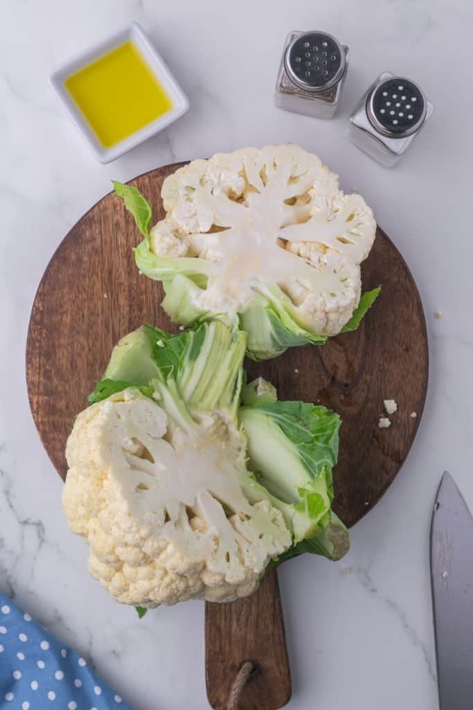 whole cauliflower on a wooden board cut in half