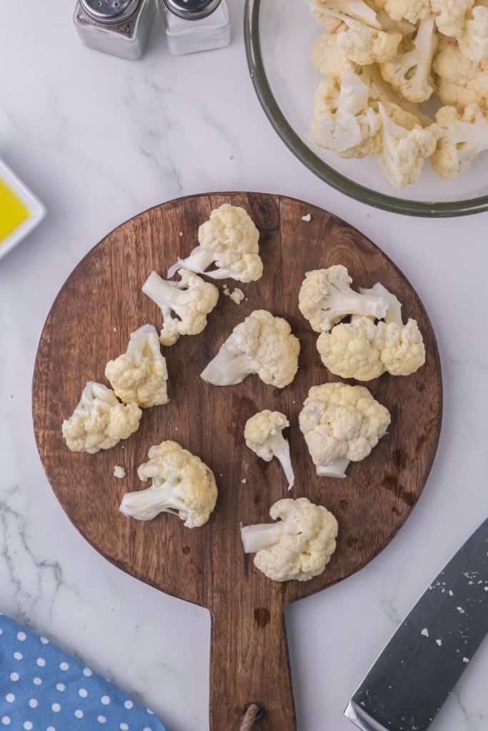 round wooden chopping block with diced cauliflower