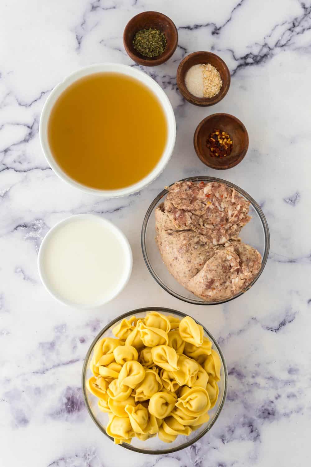 raw ingredients in portion dishes for sausage tortellini soup