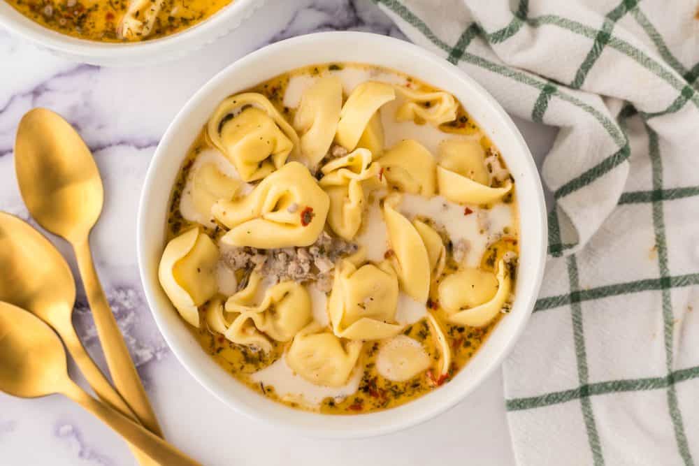 top view of two portioned bowls of sausage tortellini soup