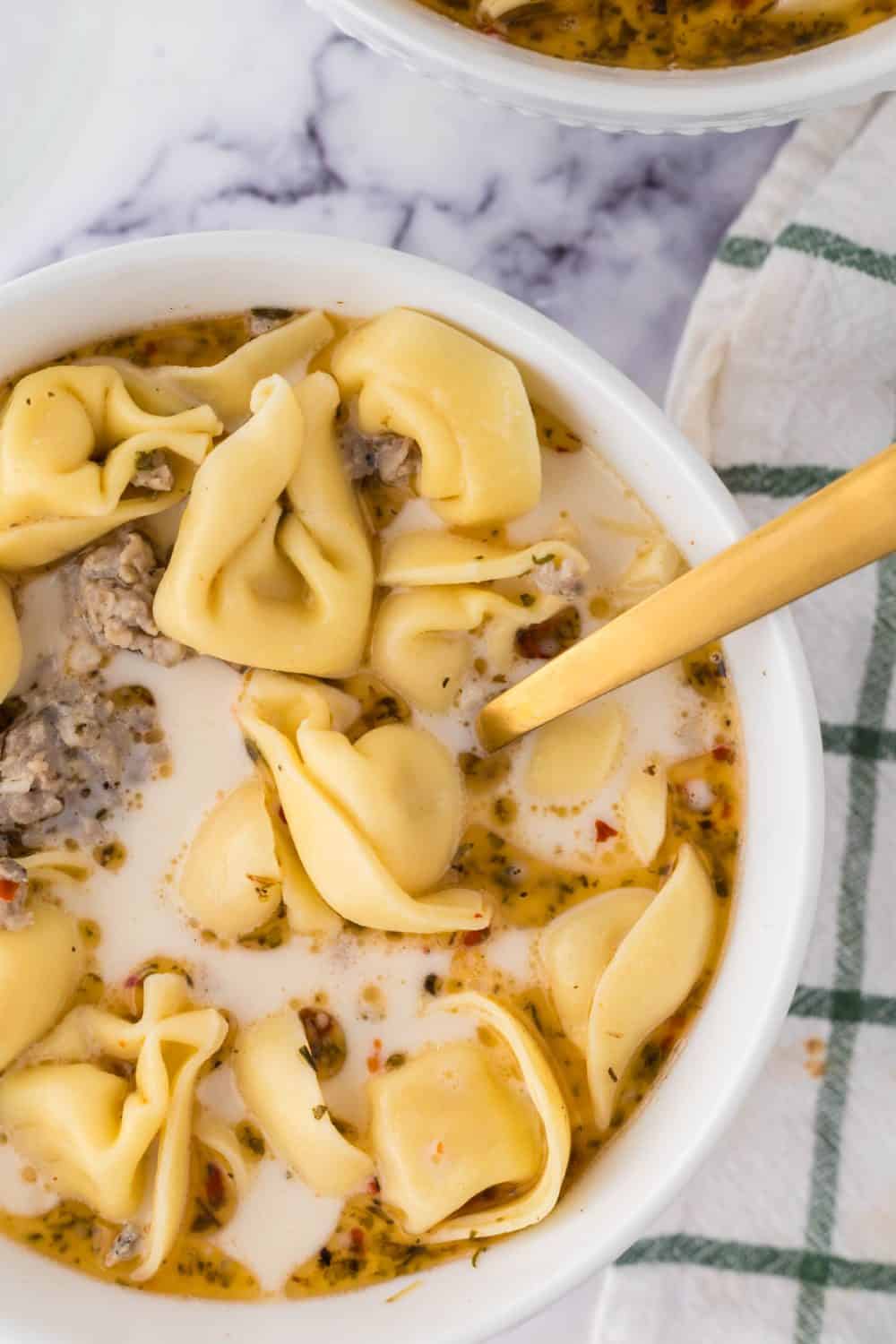 close up top view of a bowl of sausage tortellini soup