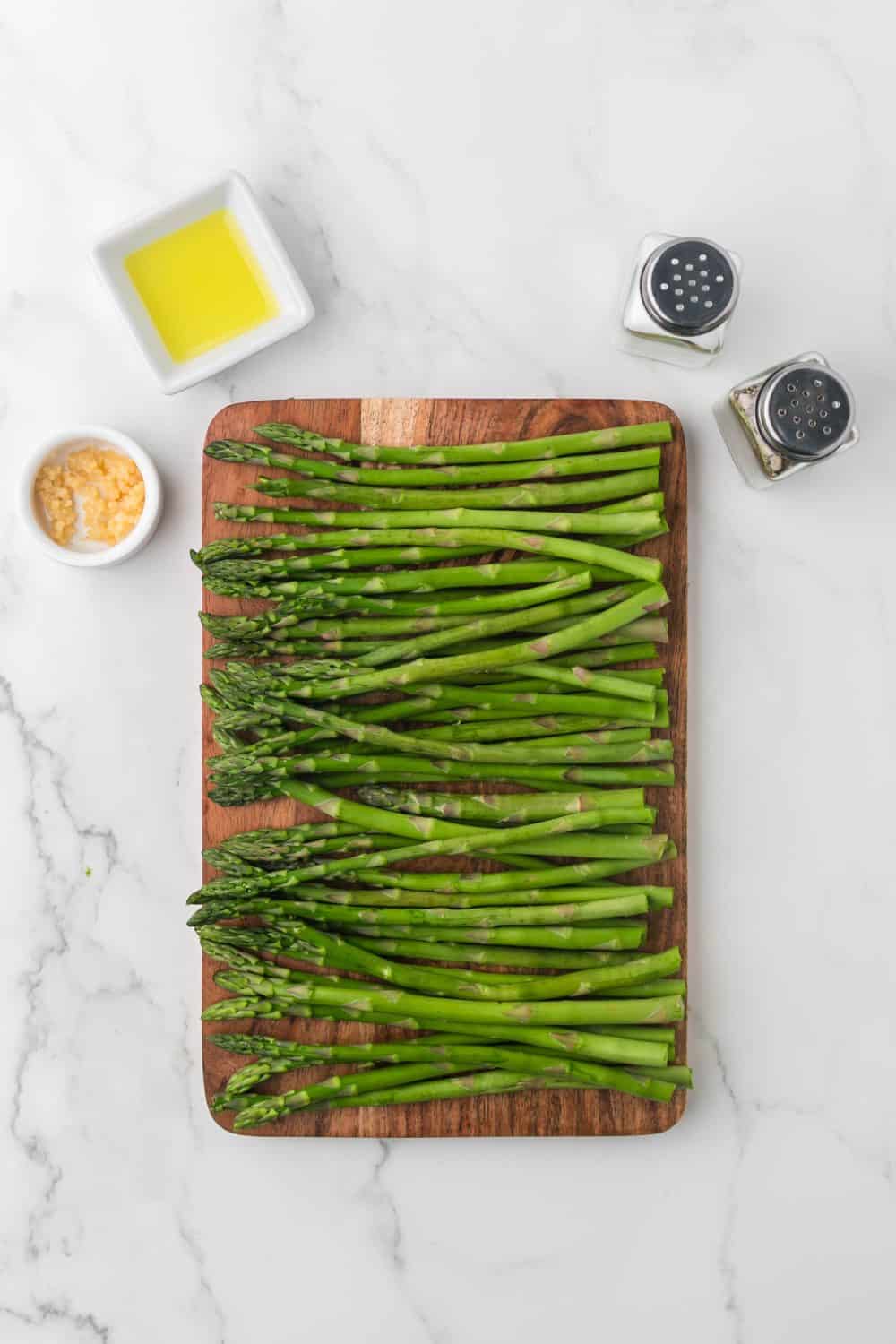 wooden cutting board of ripe green asparagus