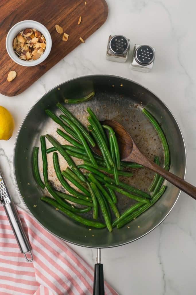 a pan for sautéed green beans with a spoon