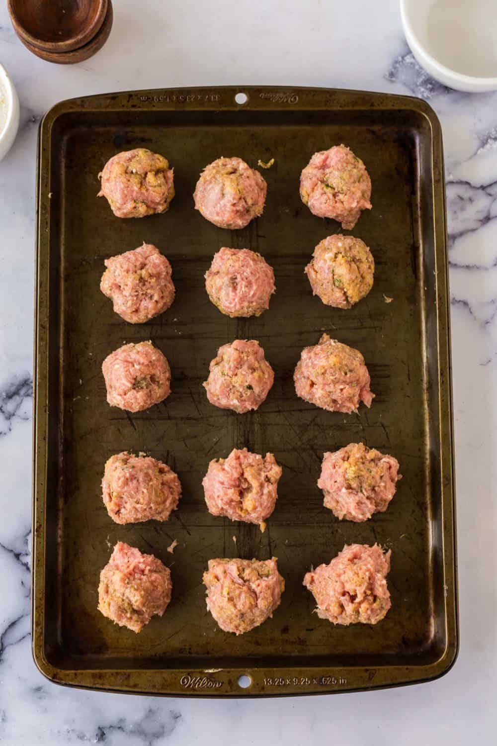 turkey meatballs raw on a baking dish