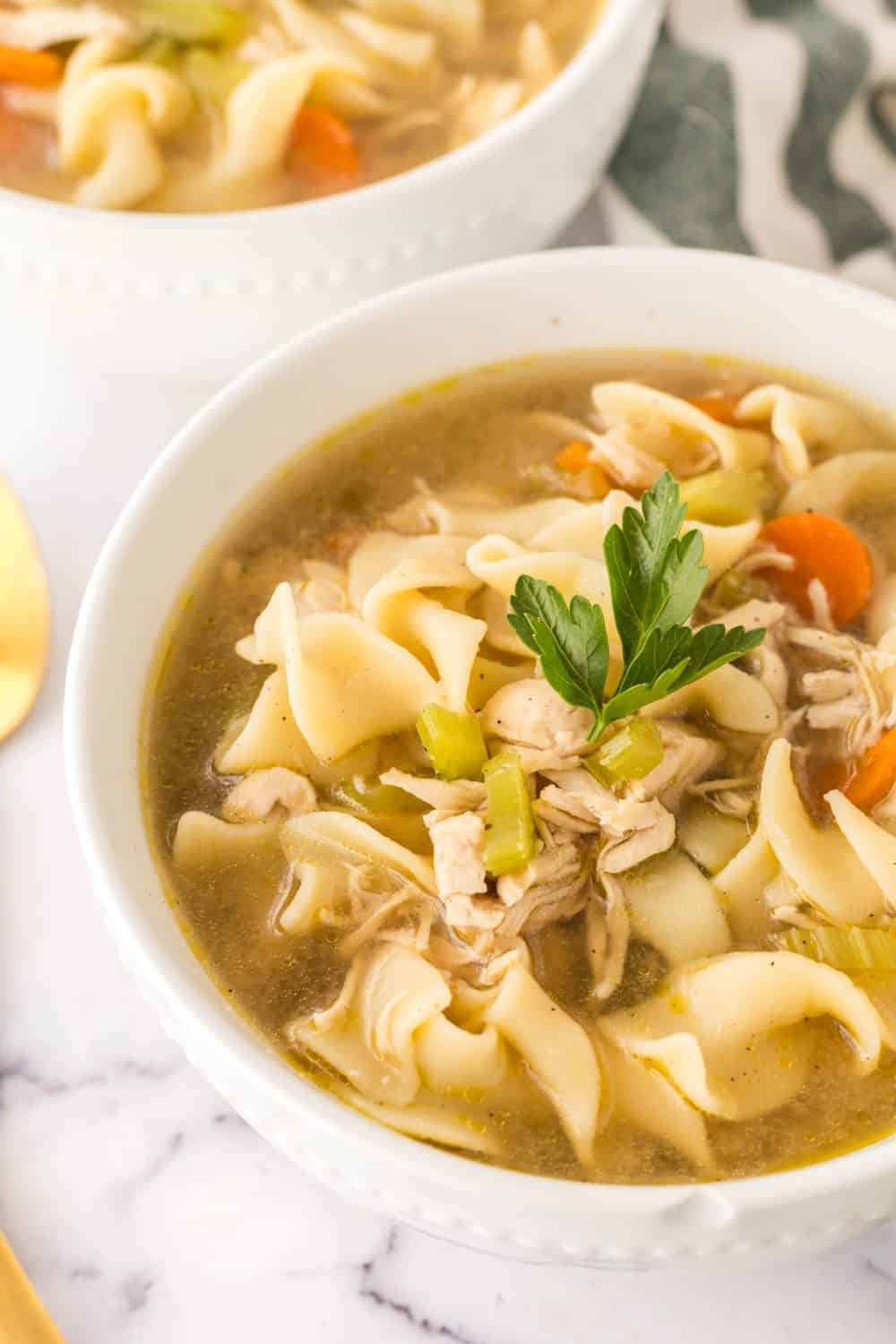 white bowl of turkey noodle soup served and ready to enjoy