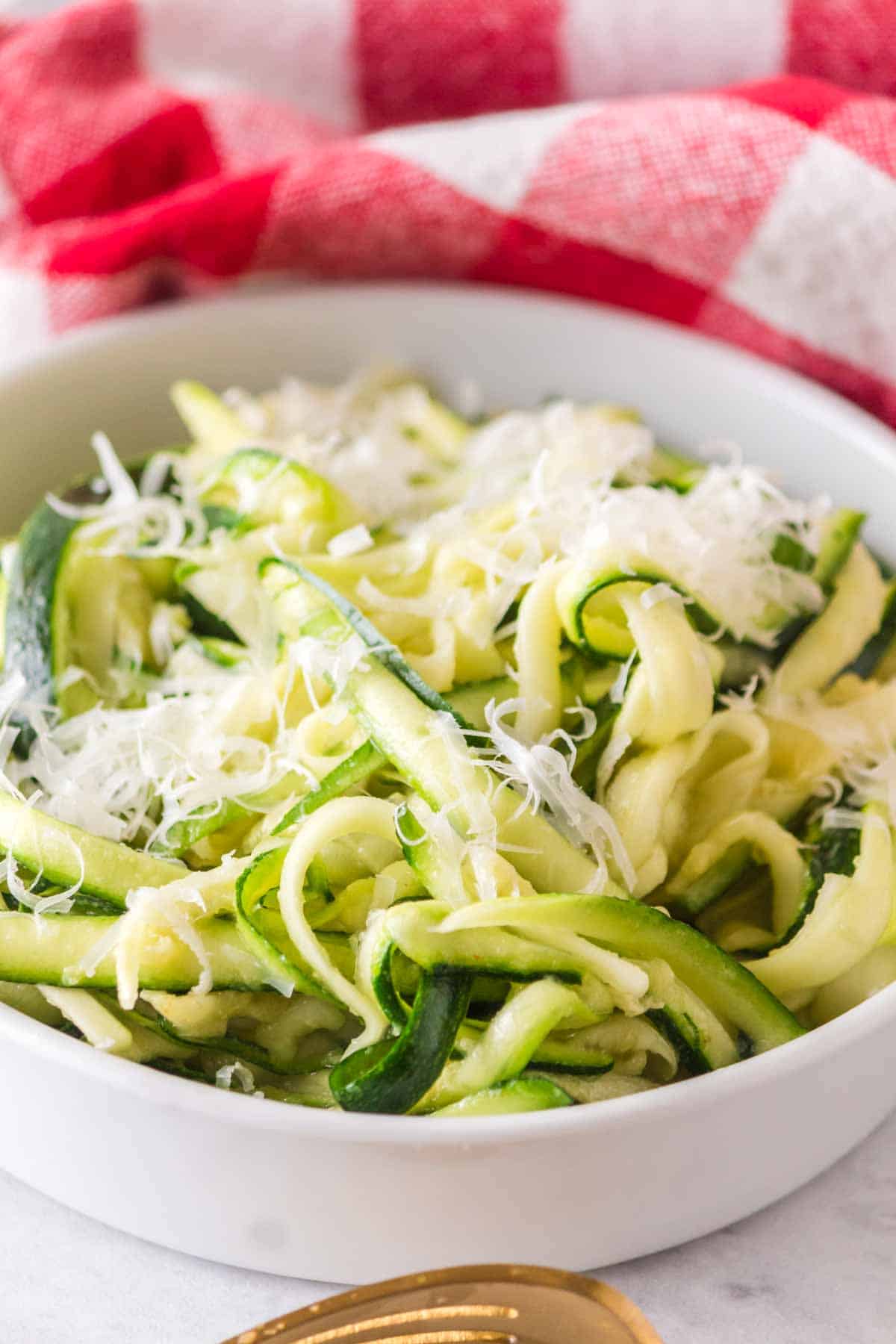 bowl of fresh zucchini noodles with parmesan on top