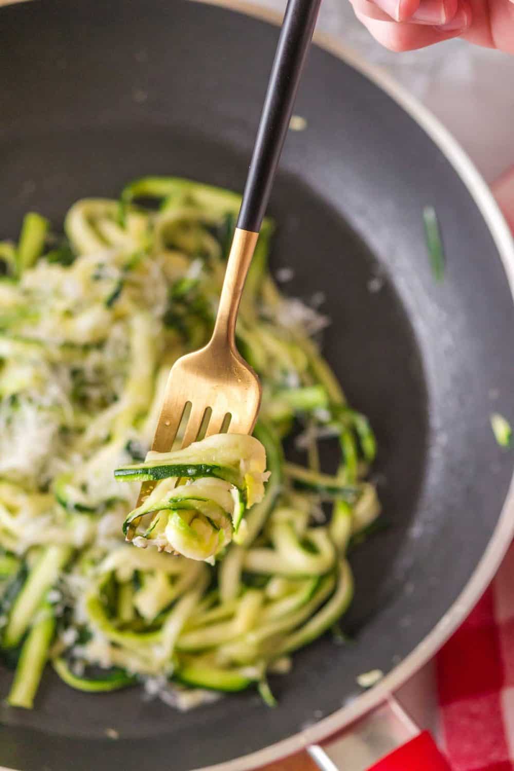 POV fork of zucchini noodles from a pan