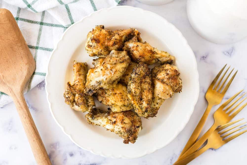 top view of a round plate of air fryer chicken wings baked and seasoned.