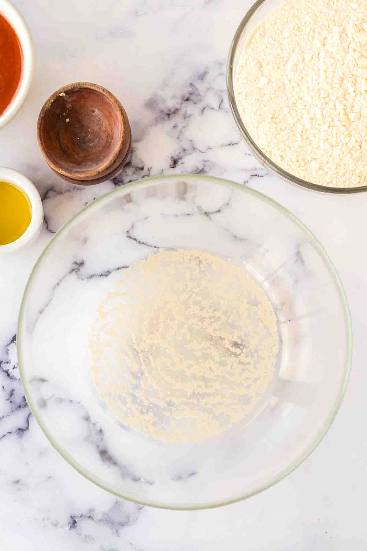 step by step of brooklyn pizza dough in the process in a clear mixing bowl