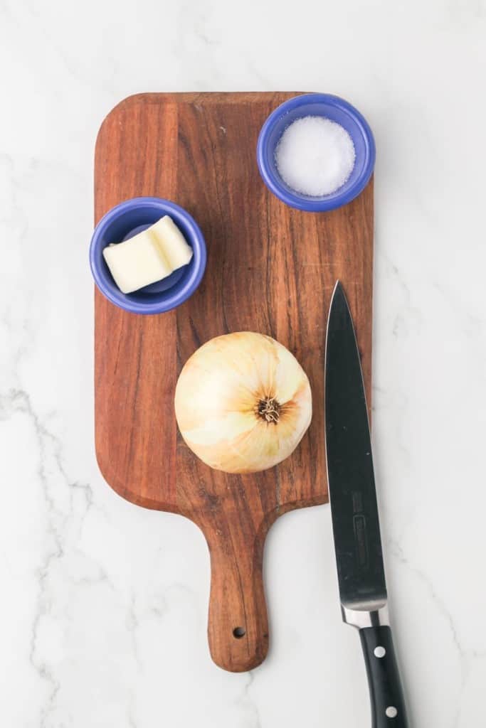 caramelized onion recipe with a white onion on a chopping block
