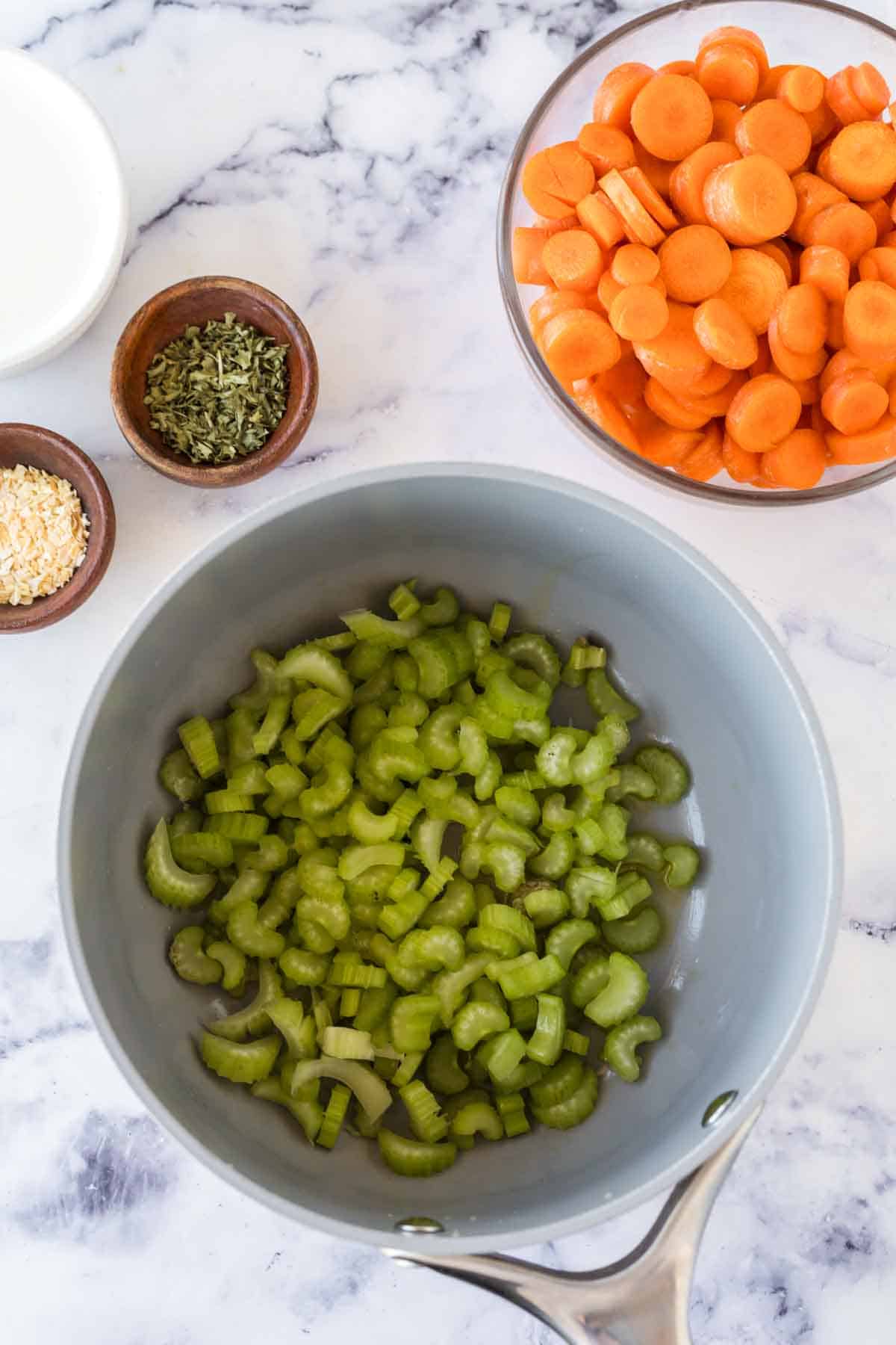 raw ingredients for carrot soup in a pot