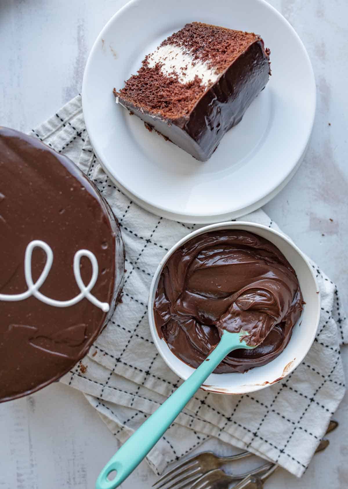 chocolate ganache whipped up in a mixing bowl next to a slice of cake