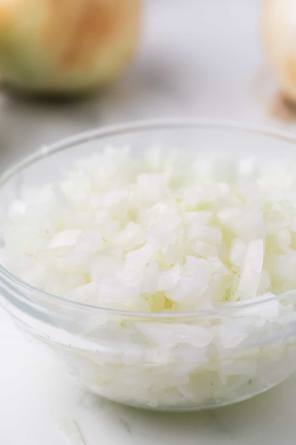how to dice an onion: diced white onion in a clear mixing bowl