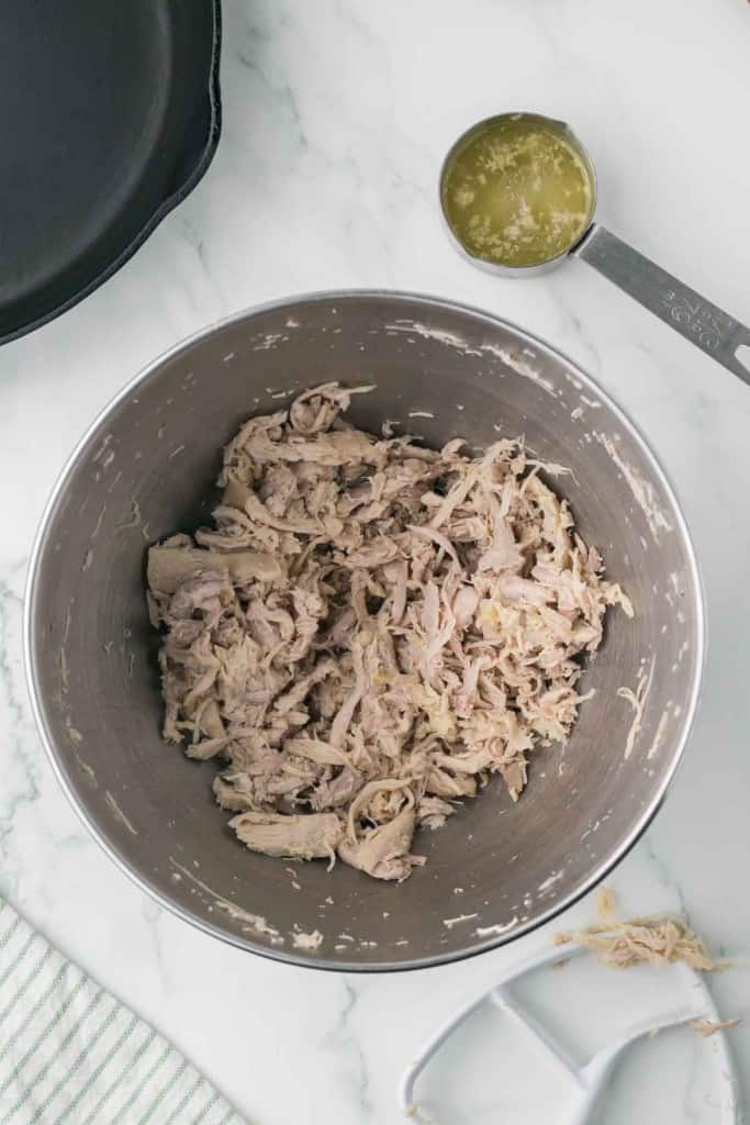 cooked and shredded chicken in a mixing bowl