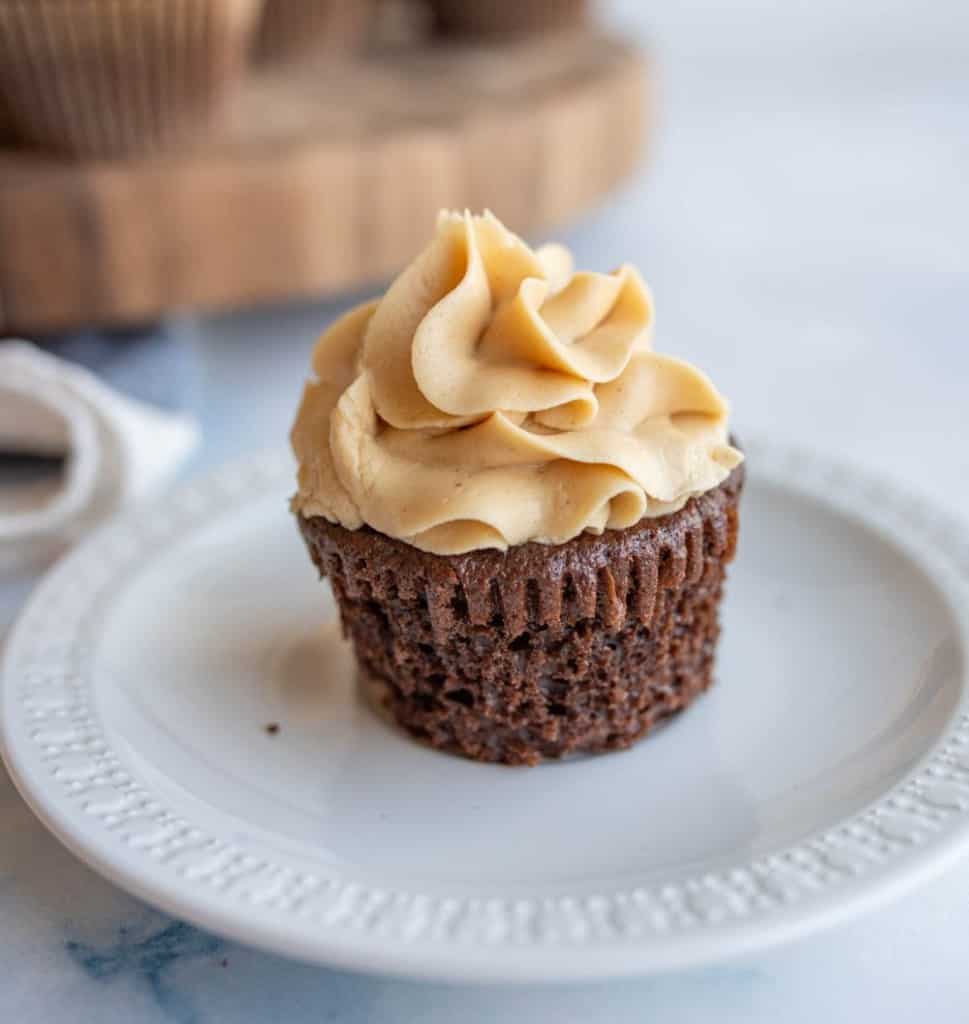 one chocolate cupcake with fluffy beige frosting pipped on top