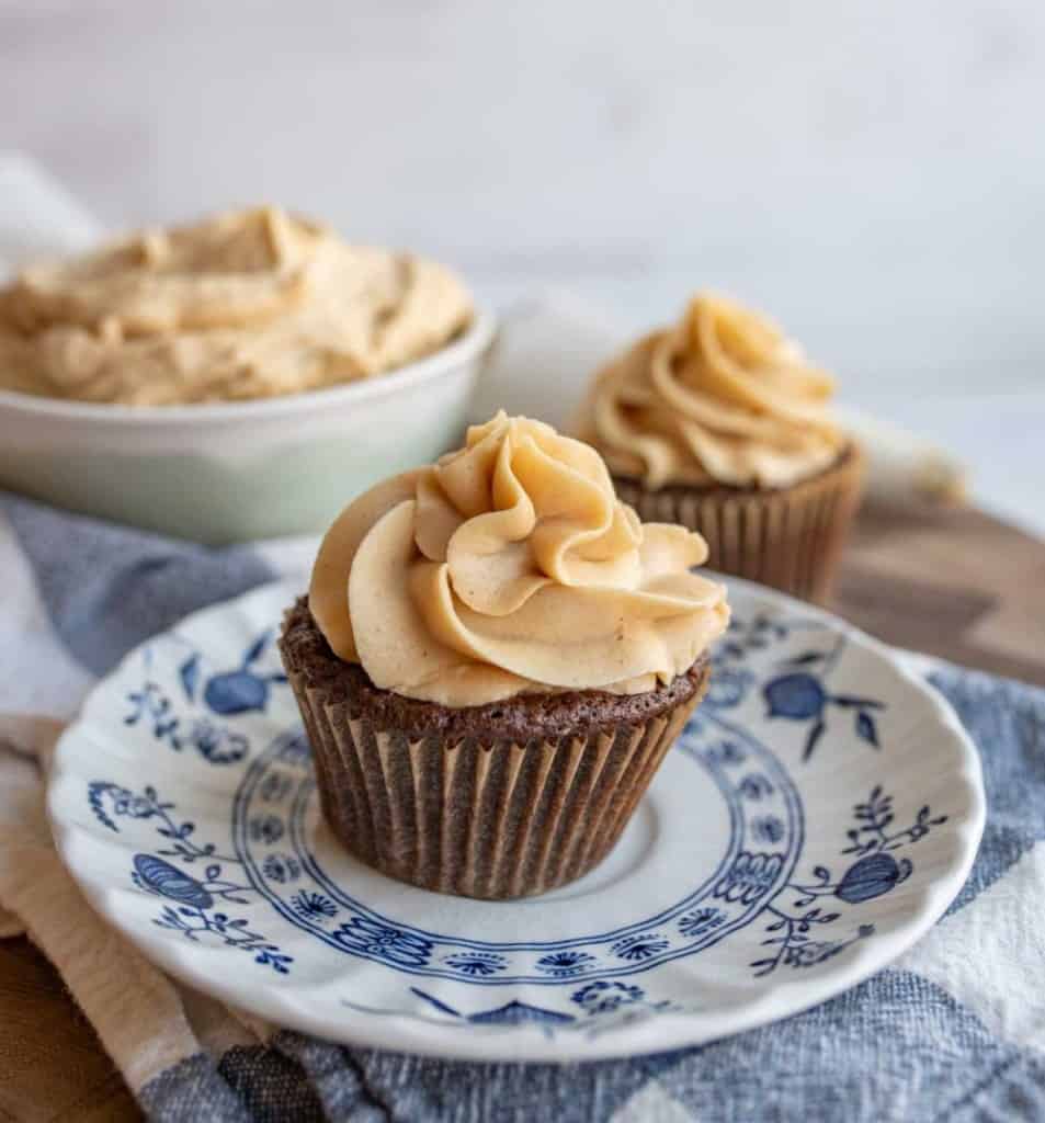 fluffy beige peanut butter icing pipped onto a cupcake