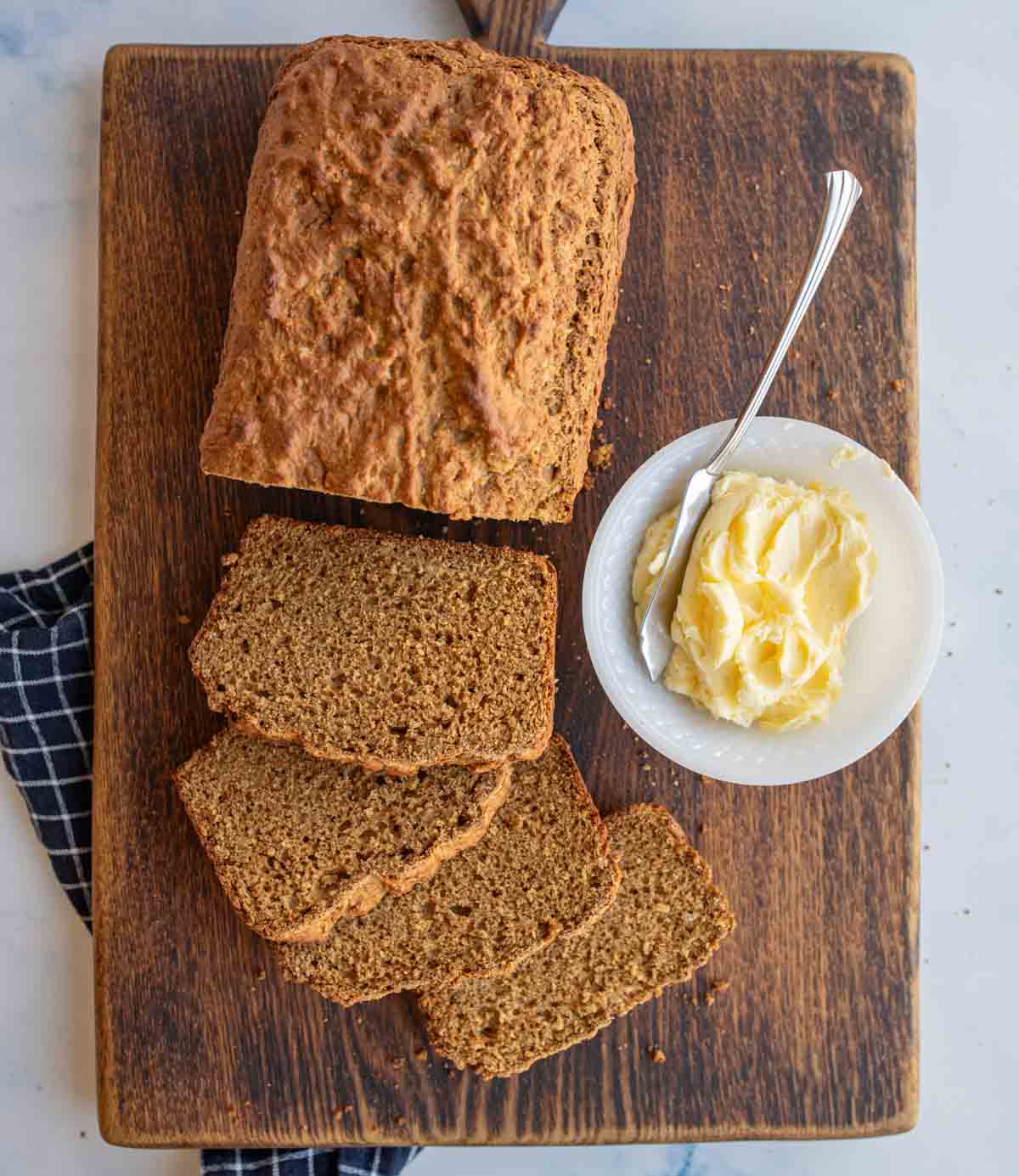 top view of a loaf of soda bread sliced and a dish of butter