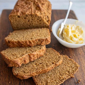 a loaf of soda bread sliced and a dish of butter