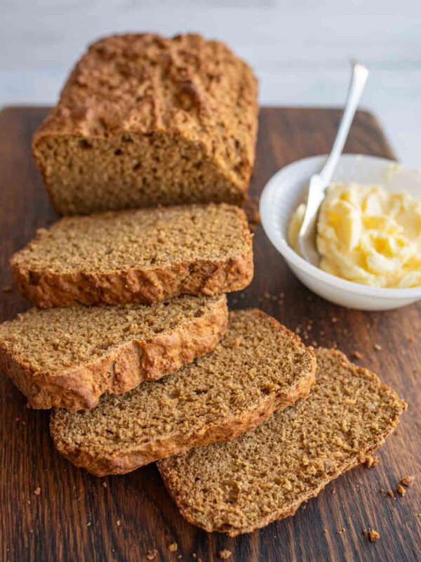 a loaf of soda bread sliced and a dish of butter