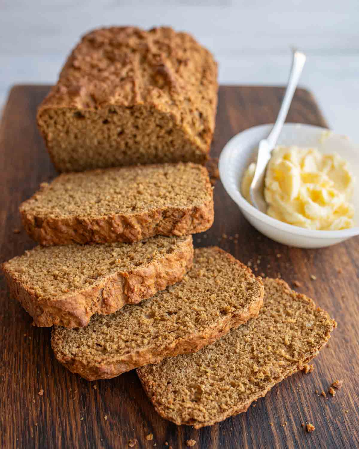 a loaf of soda bread sliced and a dish of butter