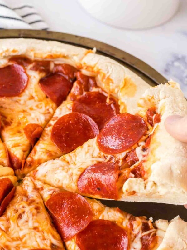 POV hand scooping a slice of stuffed crust pizza