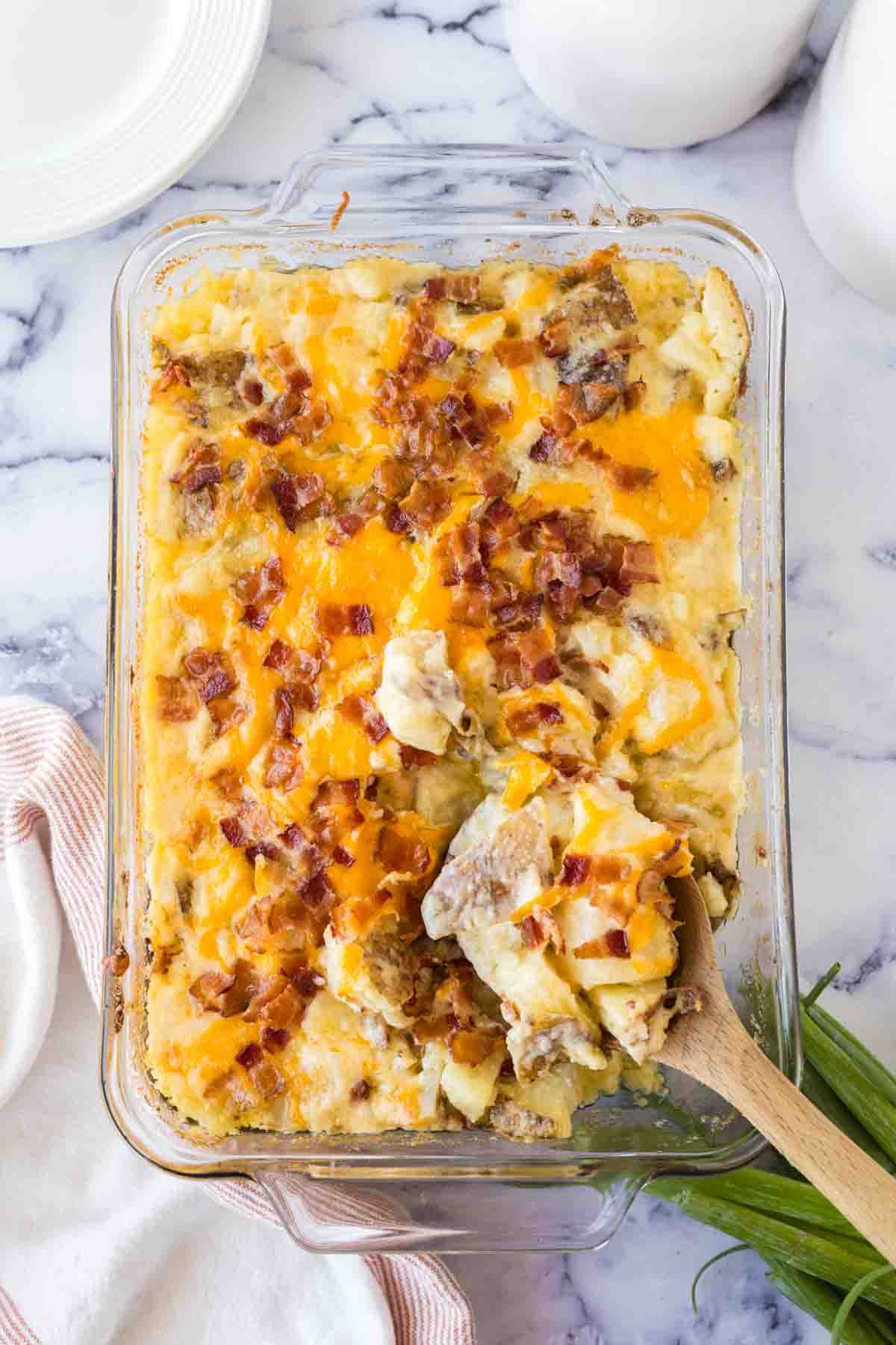 top view of twice baked casserole and a wooden spoon scooping it out