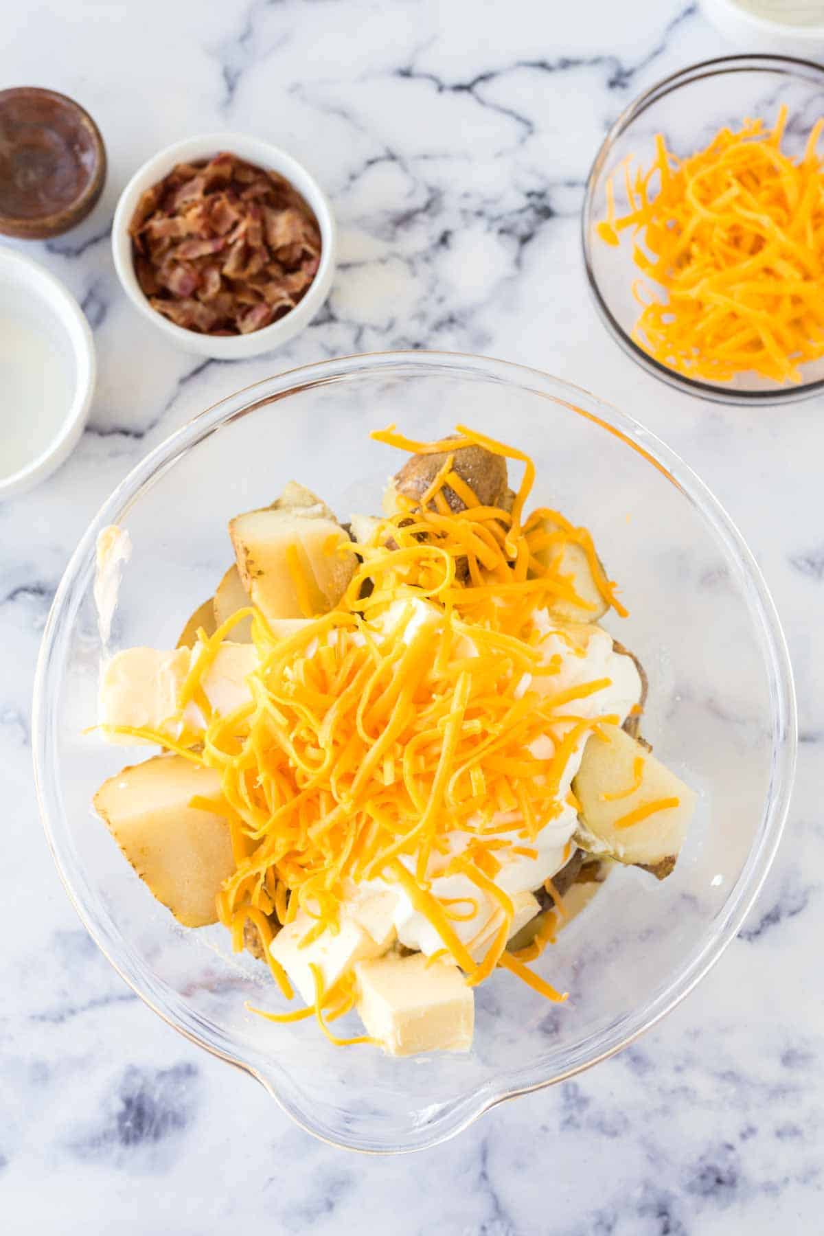 ingredients for twice baked potato casserole in a white bowl