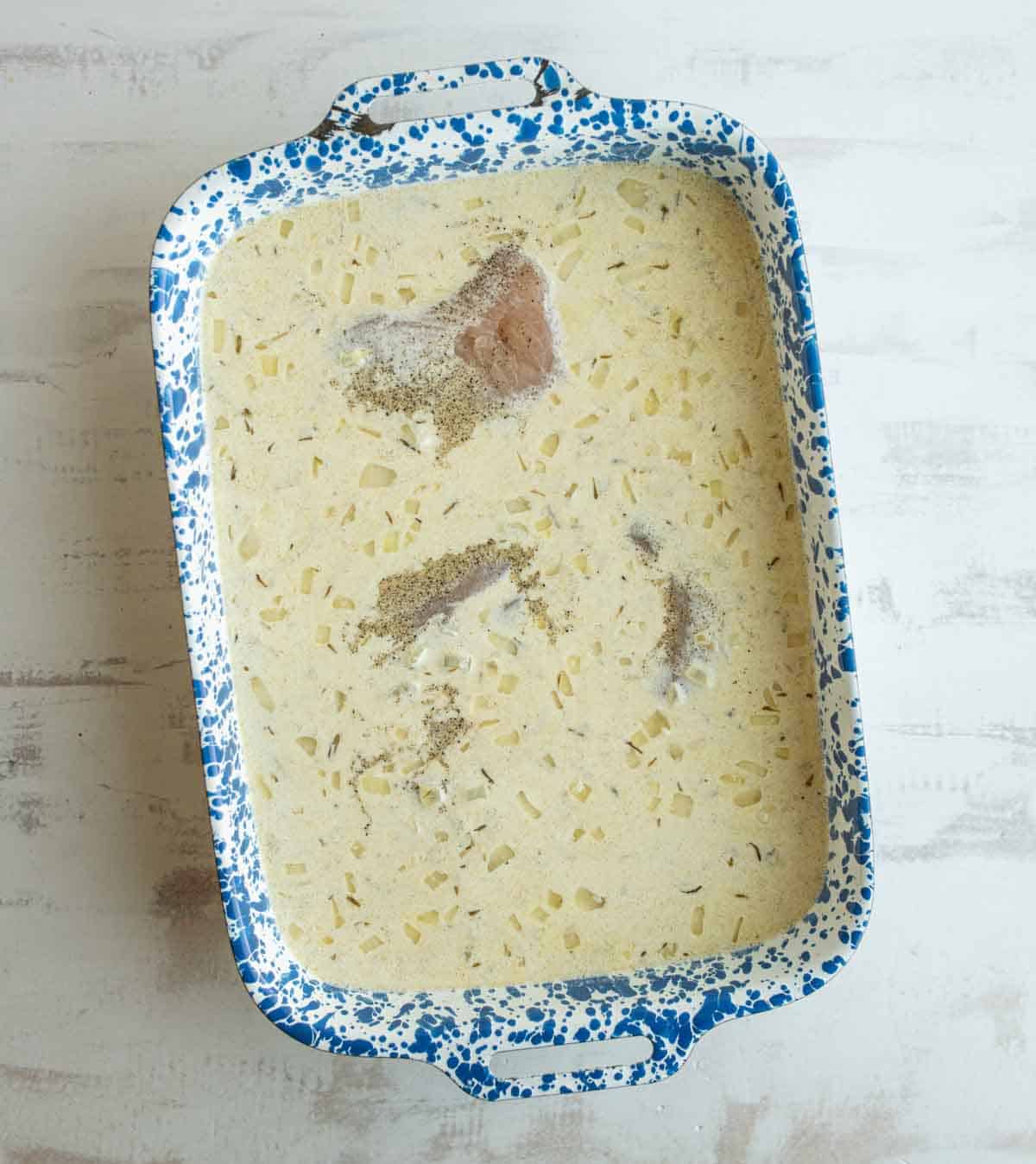uncooked chicken and rice in pan