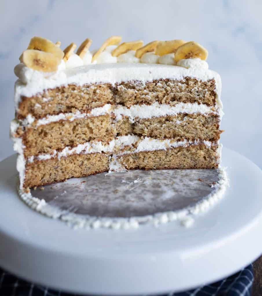 half cut three layer banana cake with white frosting