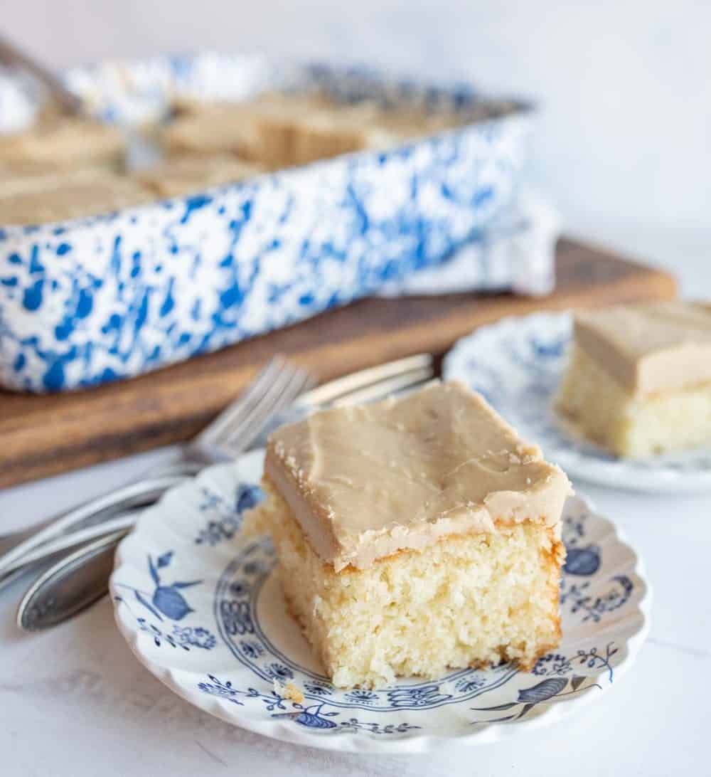 one slice of caramel cake with caramel icing on a plate