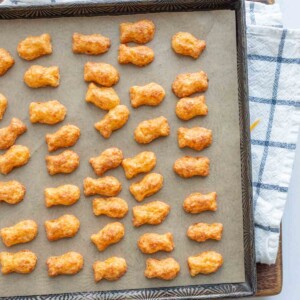 baked cheese crackers in a fish shape on a baking sheet
