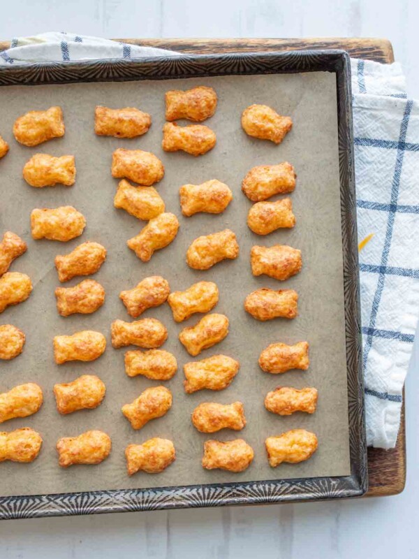 baked cheese crackers in a fish shape on a baking sheet