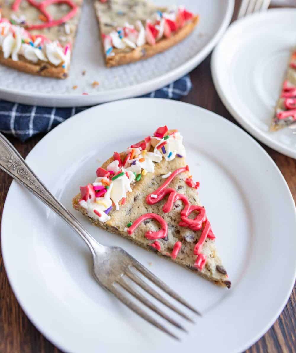 one slice of large round chocolate chip cookie cake with birthday decorations