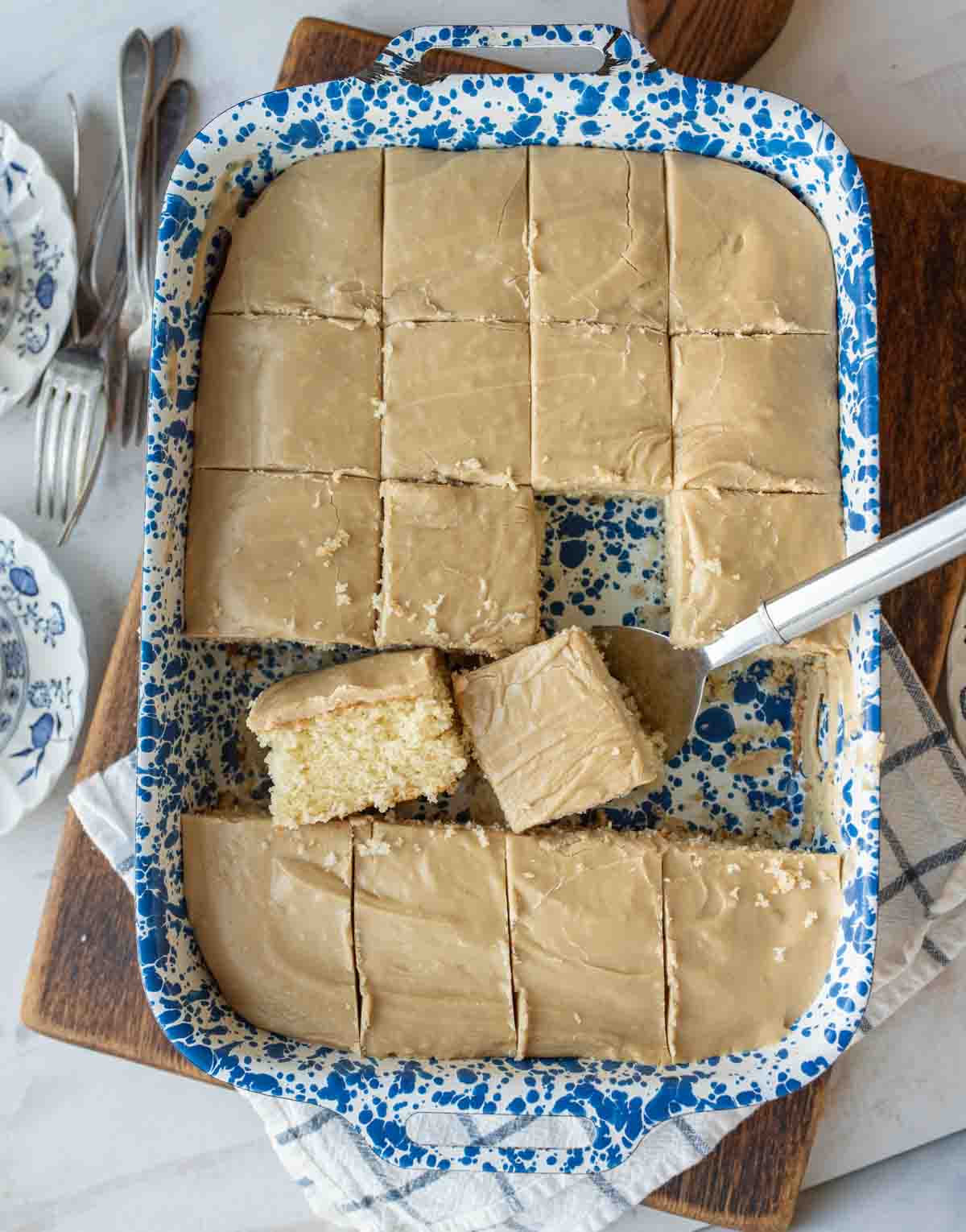 blue baking dish with squares of yellow cake cut out