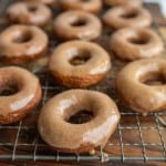 pumpkin donuts and holes glazed and on a cooling rack