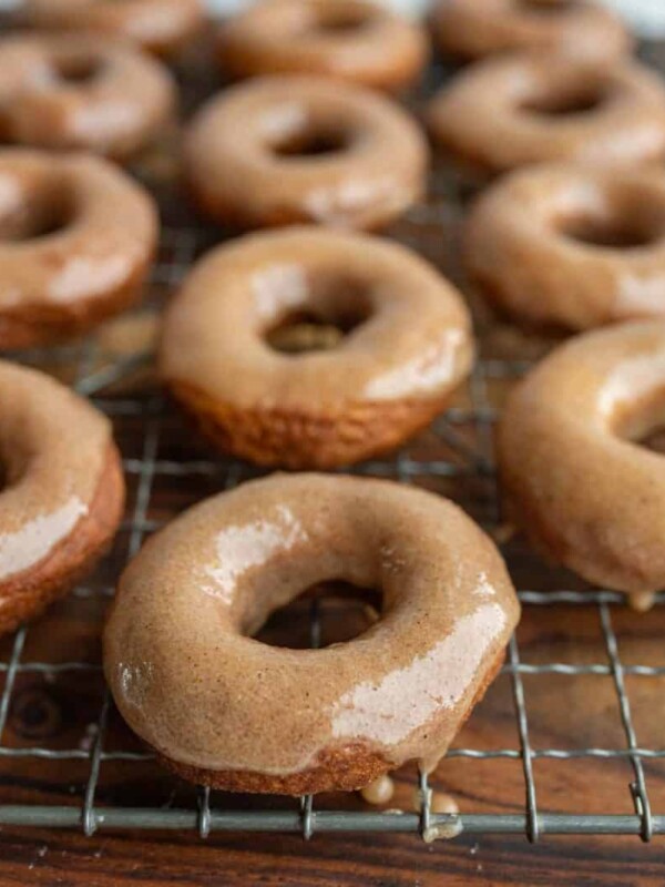 pumpkin donuts and holes glazed and on a cooling rack