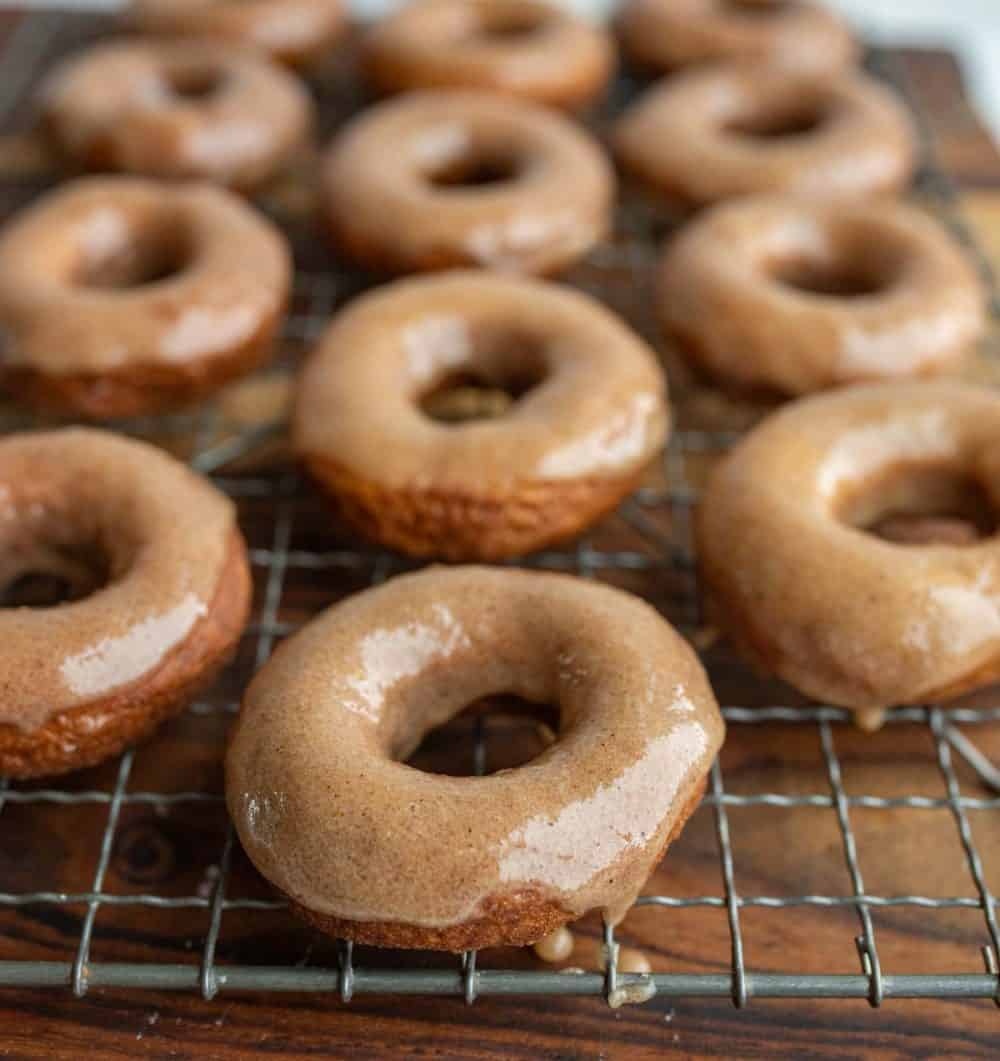 pumpkin donuts and holes glazed and on a cooling rack