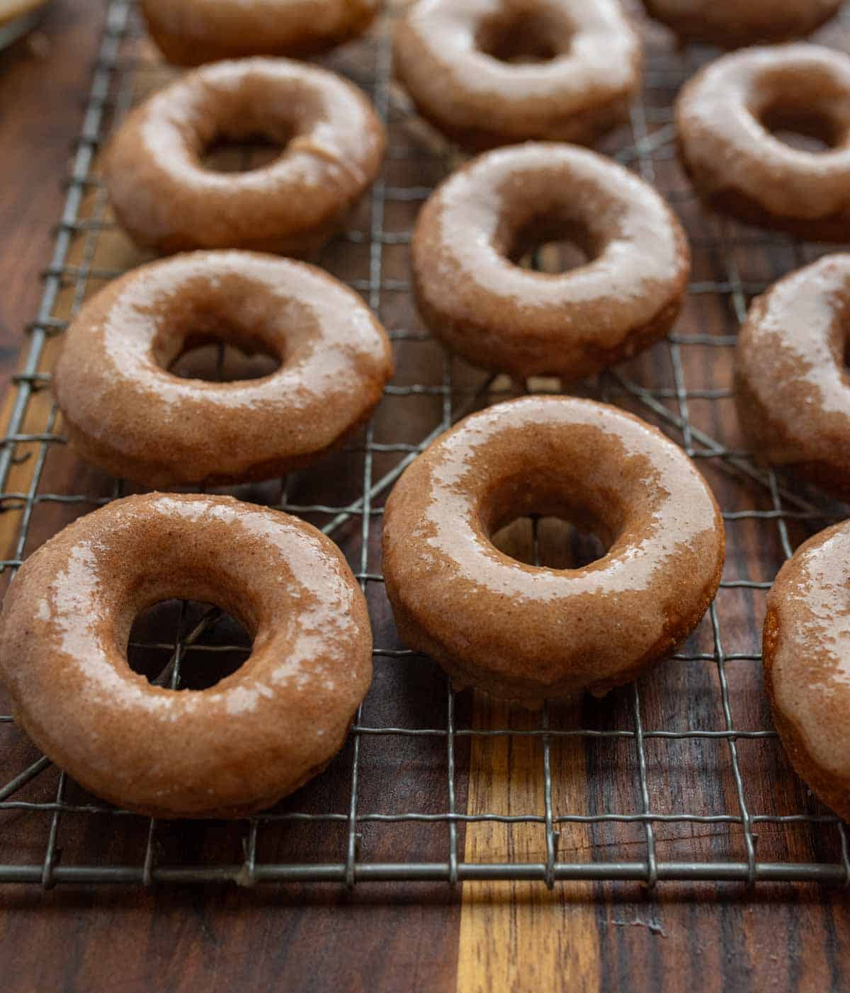 pumpkin donuts and holes glazed and on a cooling rack