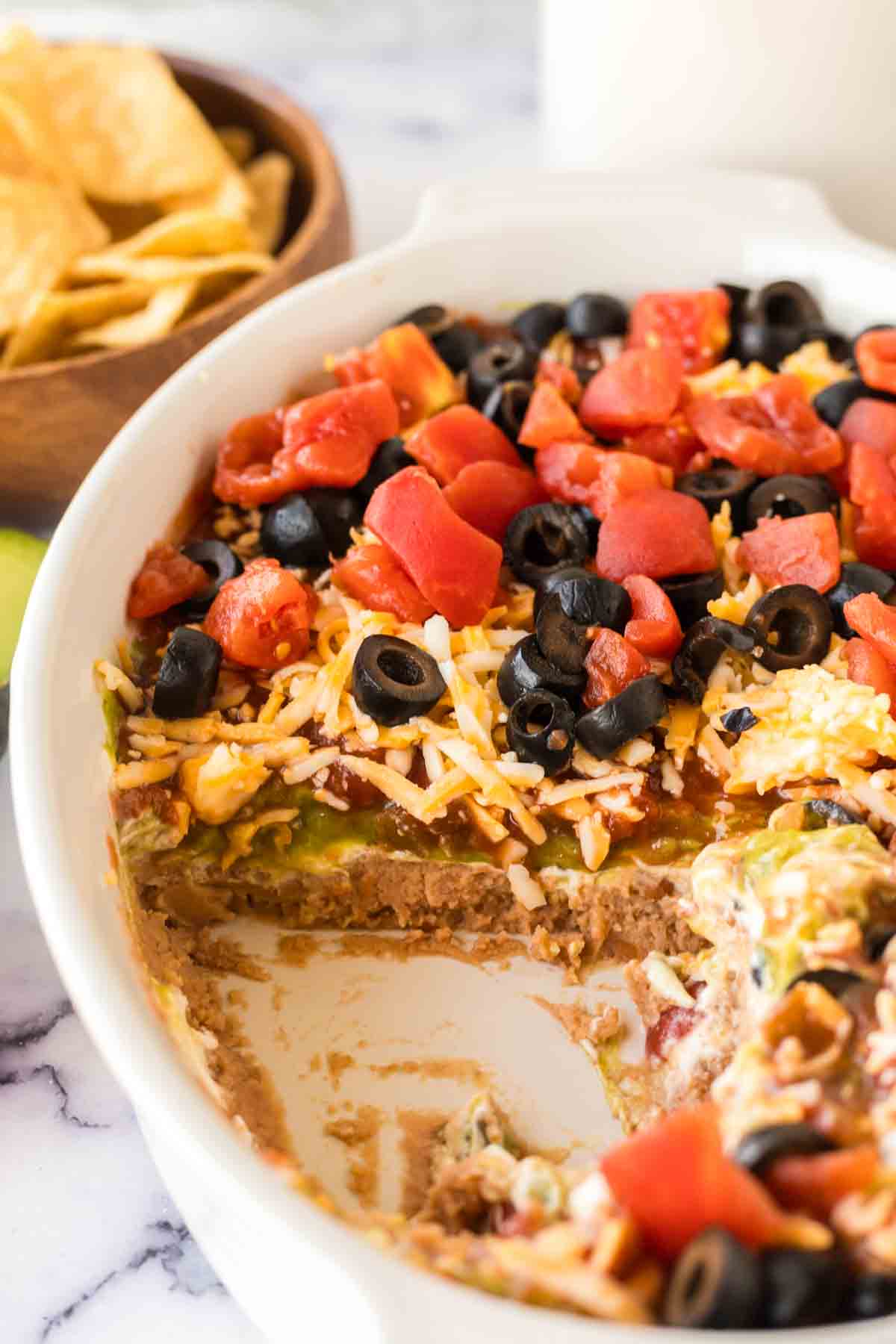 close up of a white baking casserole dish with 7 layer dip