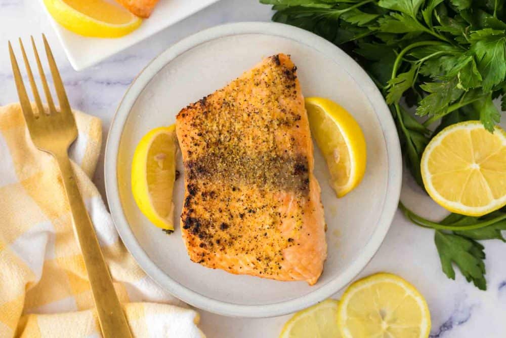 top view with a round plate and lemons with air fryer salmon recipe.