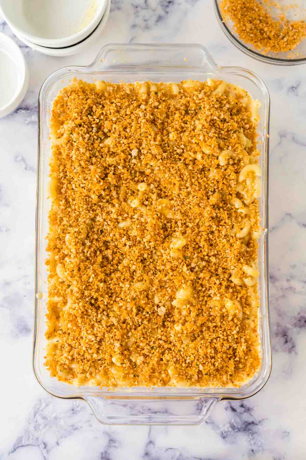 Assembled baked mac n cheese in a 9x13 dish.