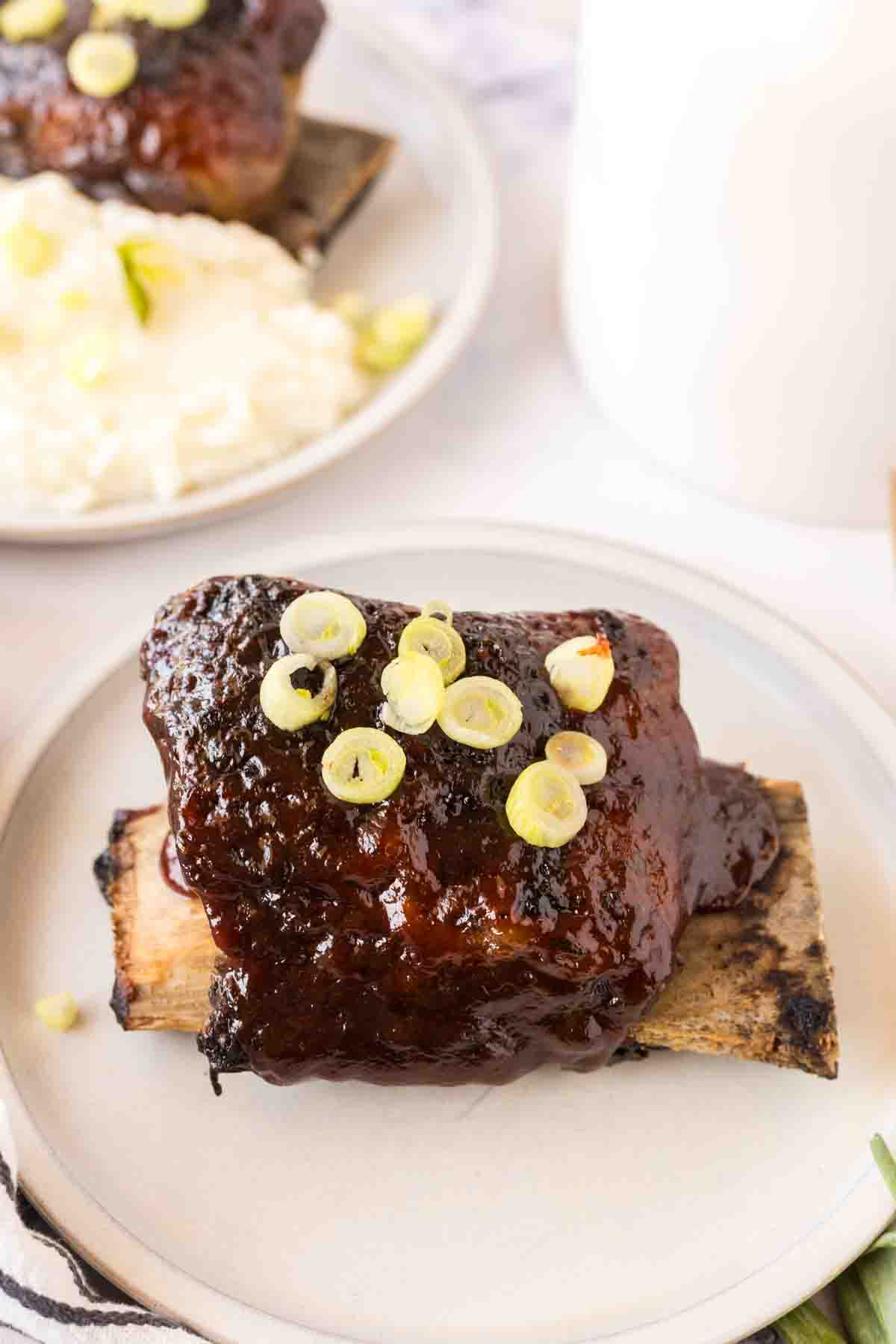 Finished beef short ribs on a white plate.