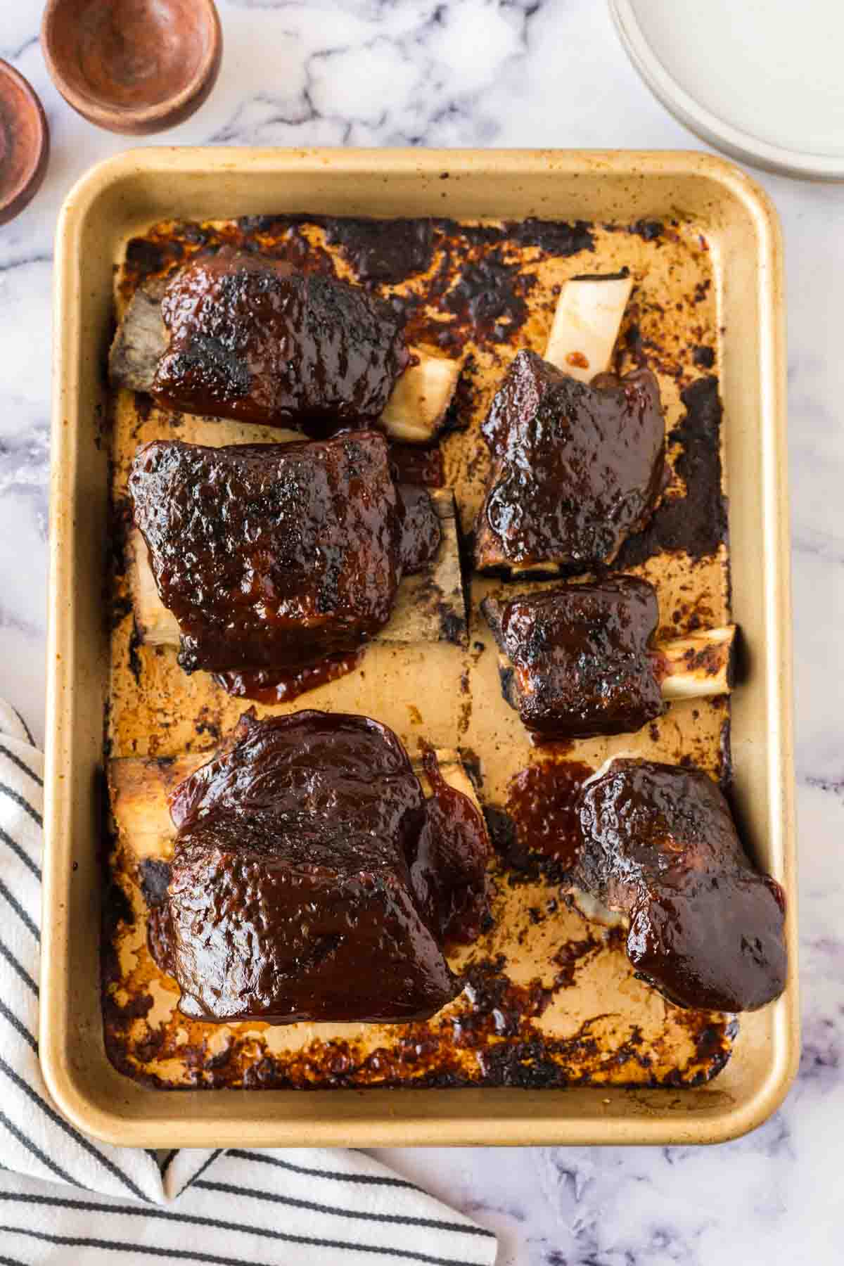 Baked beef short ribs on a baking sheet.