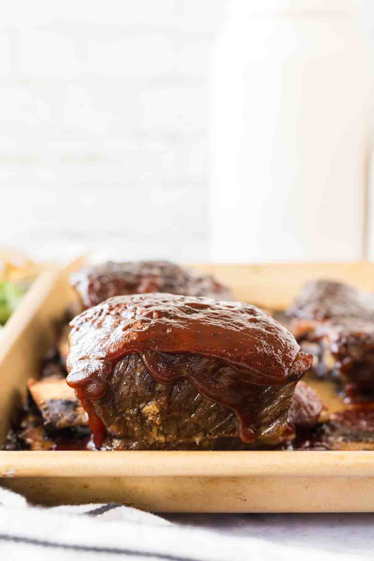 Beef short ribs covered in BBQ sauce.