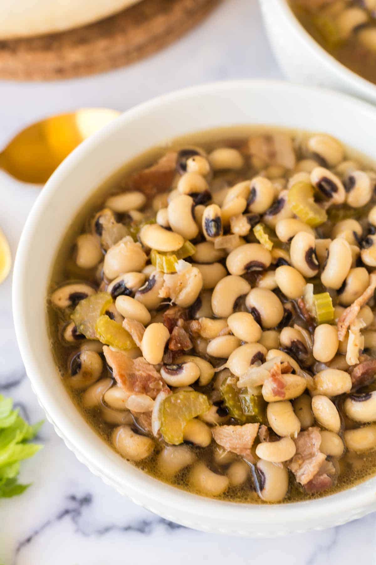 Close up view of black-eyed pea soup in a white bowl.