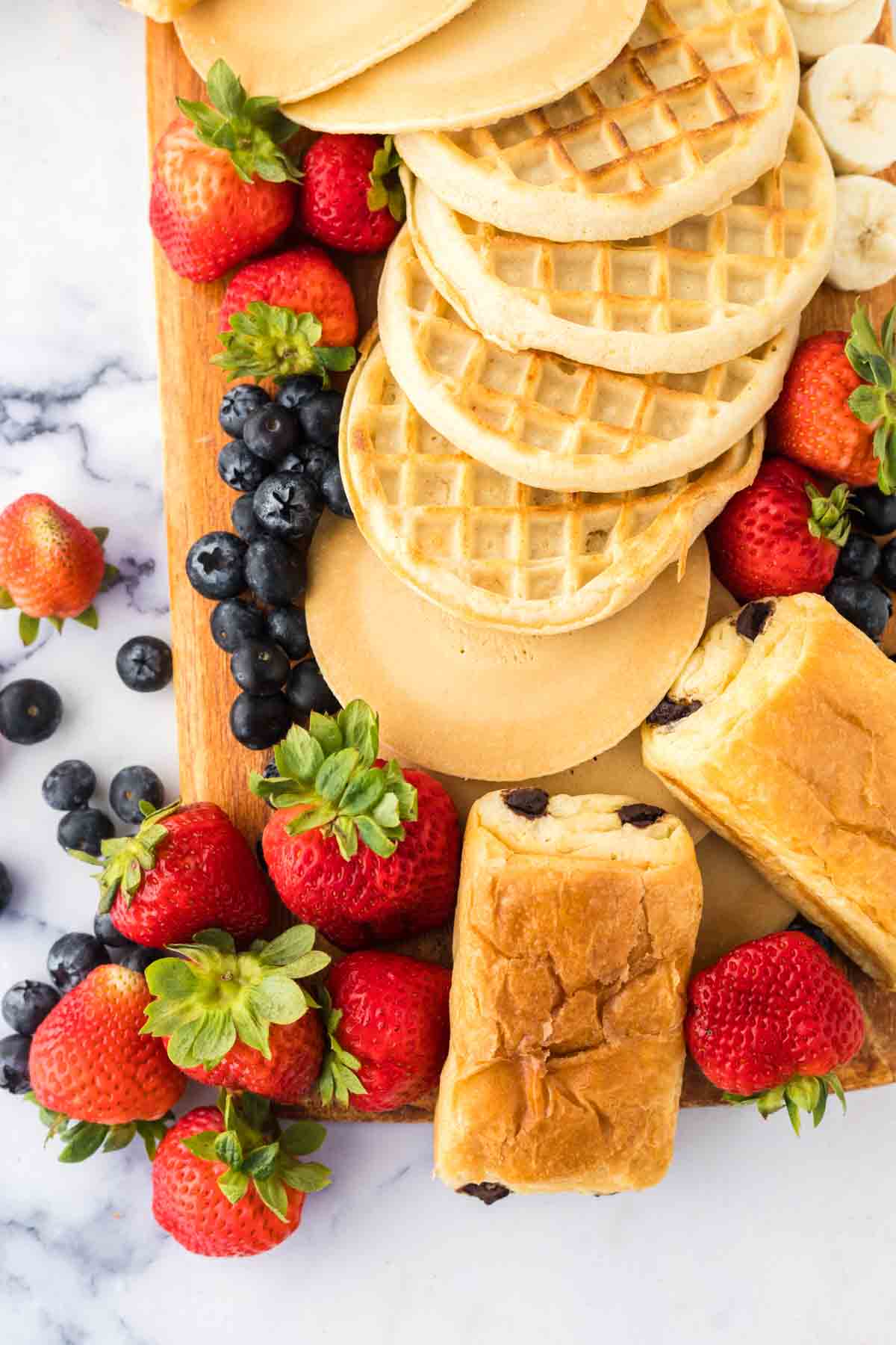 close up view of a breakfast board filled with breakfast foods and fruits.